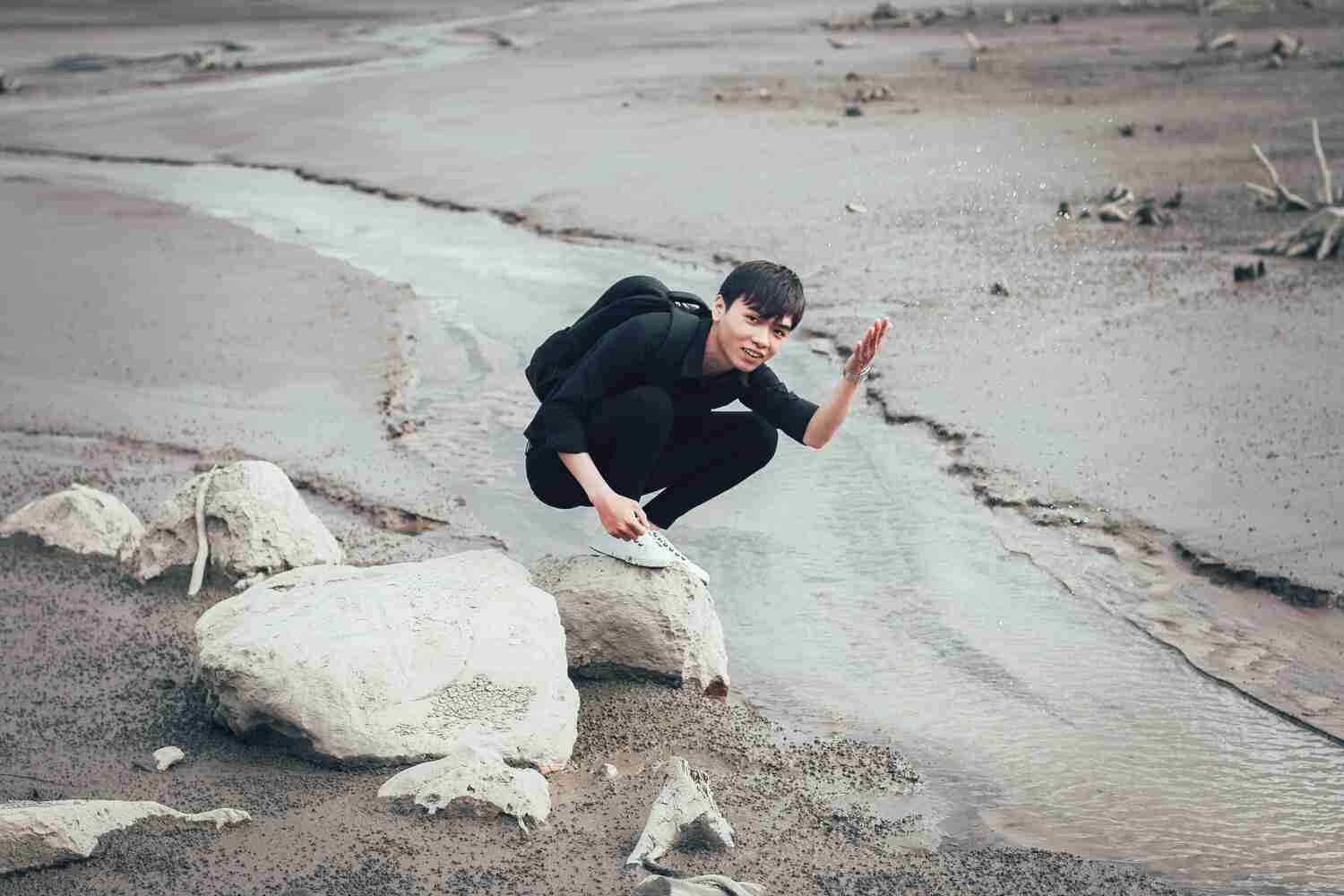 A photo of a boy in a hillside covered in mud and debris, with trees and rocks scattered throughout. Mud Floods: The Natural Disaster Threatening Mountainous Areas in the United States".