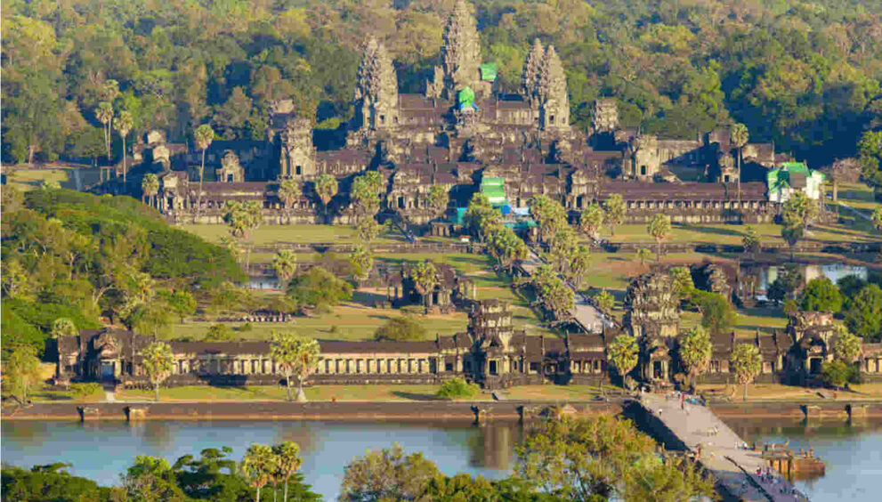 Aerial view of Angkor Wat temple complex with its iconic spires and intricate carvings, representing the world's largest religious monument and a symbol of ancient Khmer civilization.